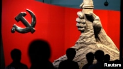 资料照:北京军事博物馆展示的中共党旗与一只握枪的手的雕塑 (路透社 2010年8月13日)