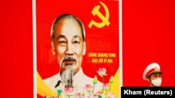 河内的越南国家会议中心外,一名戴口罩的越南士兵正在胡志明肖像前站岗。(2021年1月28日)