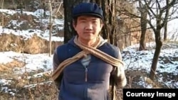 张盼成在甘肃老家村庄把自己绑在树上拍照(华涌推特照片)