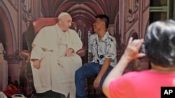 教宗方济各即将访问印尼,一名男子在雅加达大教堂与教宗的剪影合影。(美联社:2024年9月1日)