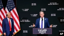 资料照片:2024年8月14日,时为共和党总统候选人的特朗普在北卡罗来纳州阿什维尔聆听投资家贝森特谈论经济问题。