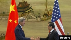 美国国务卿克里(左)与中国外长王毅2015年5月16日在北京中国外交部举行联合记者会后握手。