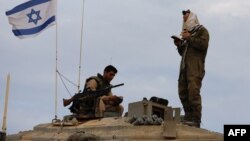 一名以色列士兵站在一辆位于以色列与黎巴嫩边界地区的坦克上祈祷。(2023年10月30日)