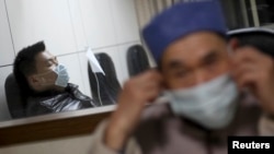 Một bệnh nhân (trái) bại sốt và được nhập viện trong tỉnh Chiết Giang để chữa trị.