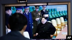 一名男子在韩国首尔火车站观看朝鲜试射“新型战术制导武器”的电视新闻,其中包括朝鲜领导人金正恩的镜头(2019年4月18日)。