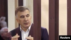 FILE - Mantan Presiden Georgia Mikheil Saakashvili, menyampaikan keterangan dari kursi terdakwa selama sidang pengadilan di Tbilisi, Georgia, 2 Desember 2021. (Irakli Gedenidze/REUTERS)