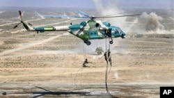 资料照:中俄军队在宁夏举行联合军演期间中国军人从直升机上进行登陆演习。(2021年8月13日)