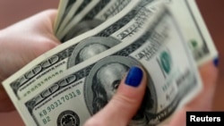 一名妇女在家中数美元(2018年8月28日)。