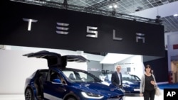 资料照:布鲁塞尔车展开幕,一对夫妇走在新款特斯拉Model X旁边。(2019年1月18日)