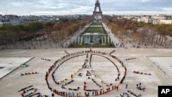 在巴黎气候峰会之际,环保人士在巴黎组成和平图标和“100%可再生”的口号(2015年12月6日)