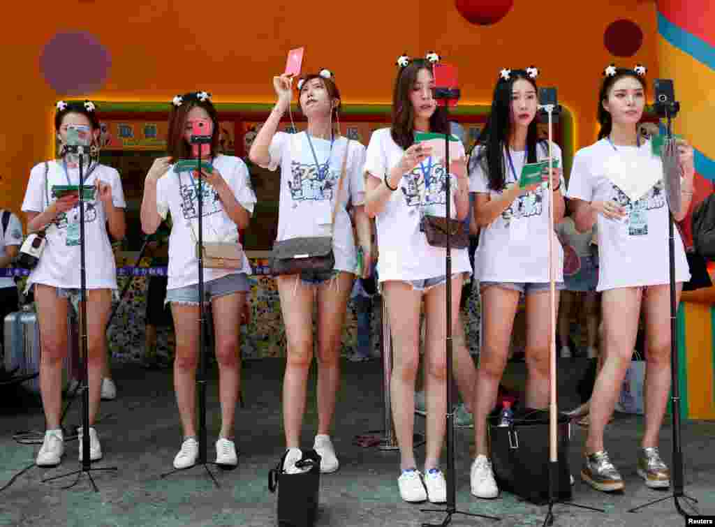 网络直播者在中国广州长隆野生动物园直播世界上唯一的大熊猫三胞胎萌萌、帅帅和酷酷的4岁生日庆生会(2018年7月29日)。