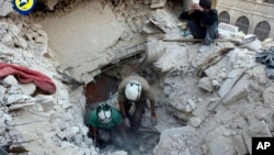 叙利亚民防队提供的这张照片显示,在阿勒颇的布斯坦艾巴夏区遭到空袭之后,“白盔”志愿救援组织的民防人员在废墟中挖掘尸体,并寻找生还者。