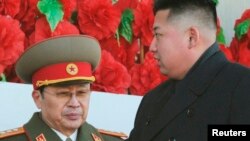 Lãnh tụ Bắc Triều Tiên Kim Jong-un (phải) cùng với ông Jang Song Thaek tại một buổi diễu hành quân đội kỷ niệm sinh nhật nhà lãnh đạo quá cố Kim Jong-il ở Bình Nhưỡng, 16/2/2012. REUTERS/Kyodo