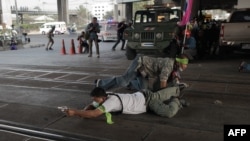 2月1日泰国曼谷,支持选举的人士边隐蔽边用枪瞄准对立派抗议人士