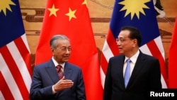 马来西亚总理马哈蒂尔(左)与中国总理李克强在北京人大会堂的签约仪式上。(2018年8月20日)