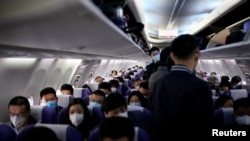 上海虹桥国际机场乘坐一架上海航班的旅客都戴着口罩防止感染新冠病毒。(2020年3月25日)