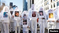 Những người biểu tình hôm 24/3 cầm hình ảnh các nạn nhân thiệt mạng trong các vụ xả súng ở trường học.