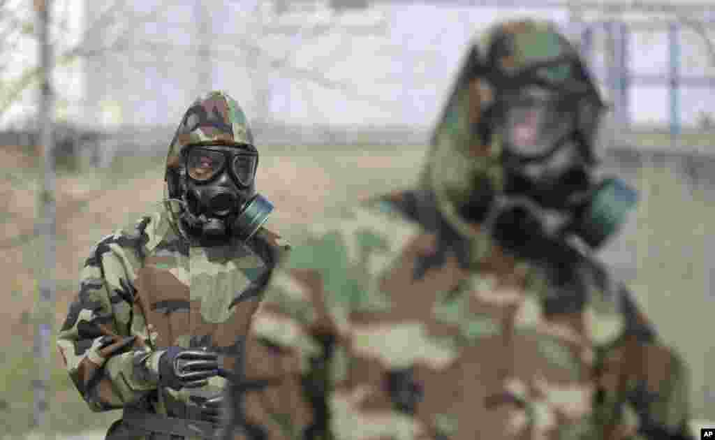 4月4日在韩国首尔以北议政府的斯坦利军营举行的表彰返回第二陆军师的官兵仪式上,美国士兵戴着毒气面罩演示他们的军事设备。