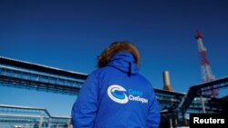 资料图:俄罗斯天然气工业股份公司一位身着带有“西伯利亚力量”标识的外套的员工在该公司“西伯利亚力量”天然气管道设施旁(2019年11月29日)