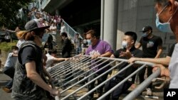 Những người đeo khẩu trang giận dữ tháo dỡ những rào chắn do sinh viên biểu tình dựng lên tại trung tâm Hong Kong, ngày 13/10/2014.