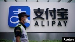一名保安站在蚂蚁集团支付宝上海办公室的标识前。(2020年9月22日)