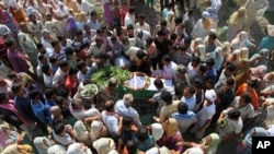 一名在印度东北部的曼尼普尔邦被反政府分子袭杀的军人家属和其他人士聚集在他的遗体身旁。(2015年6月7日)