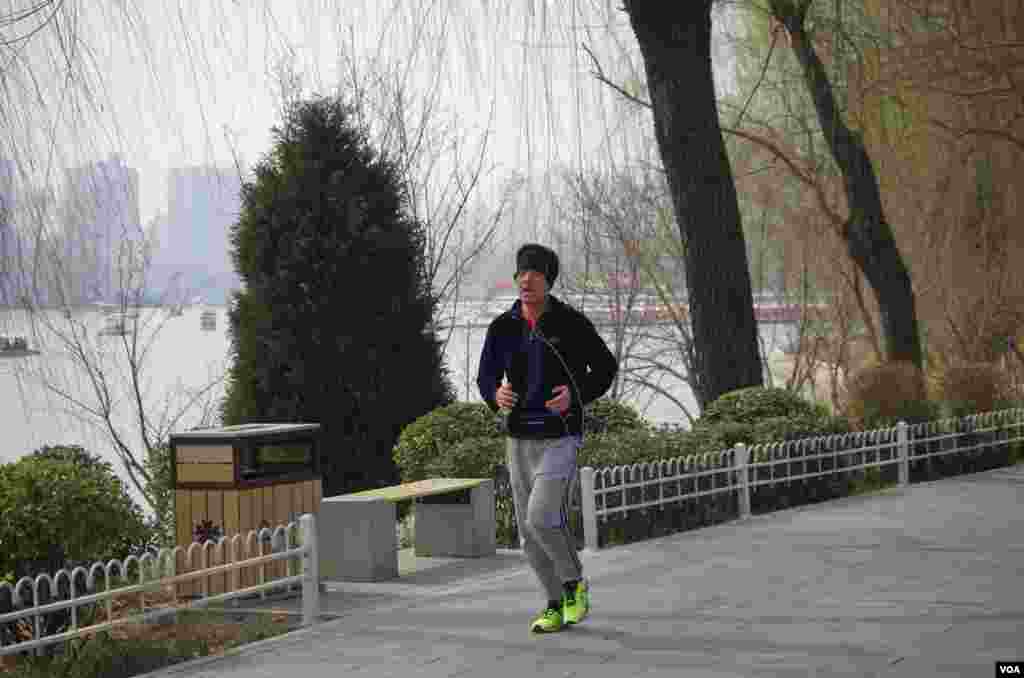 尽管雾霾严重,仍有市民不畏恶劣天气在湖边坚持锻炼 (曾谙 摄于2016年3月21日)