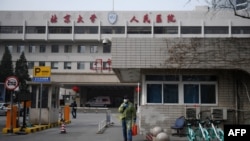 一名戴着口罩的男子走出北京大学人民医院的大门。(2020年2月21日)