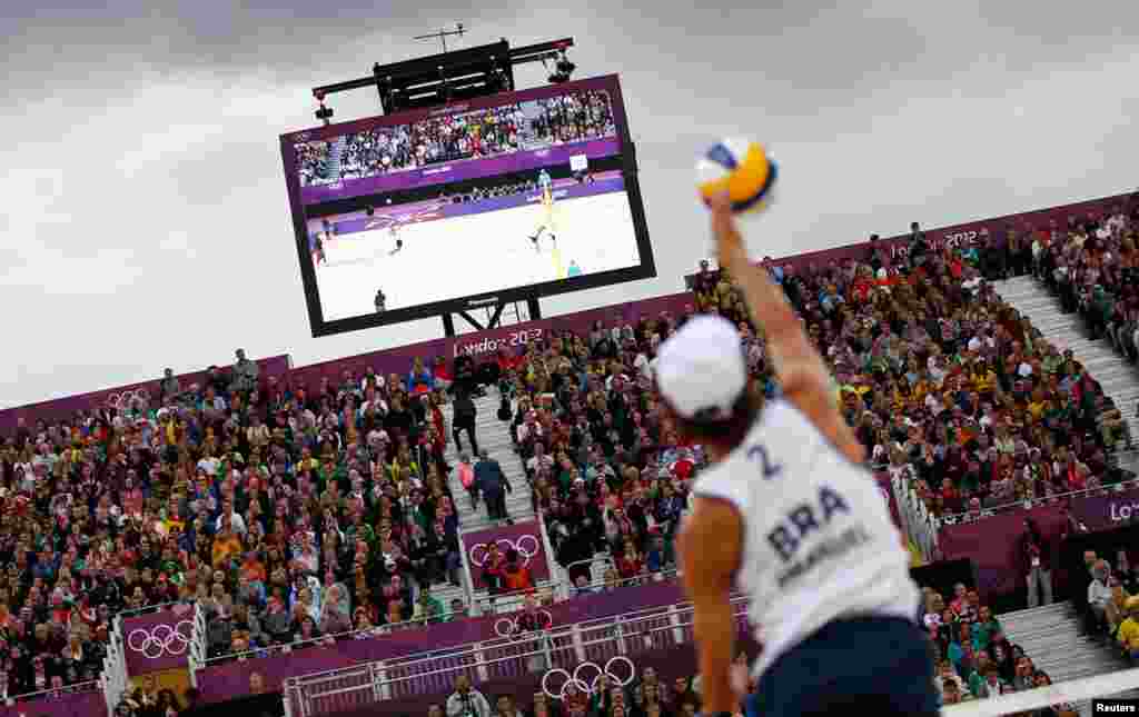 Khán giả chăm chú theo dõi cầu thủ Emanuel, Brazil giao banh trong trận gặp Mariusz Prudel và Grzegors Fijalek, Ba Lan trong trận bán kết giải bóng chuyền trên bãi biển (REUTERS/Marcelo del Pozo)