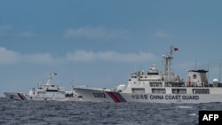 2024 年 8 月 26 日,一艘中国海警船(右)驶过菲律宾海警船 BRP Cape Engaño(左)。