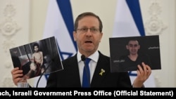 以色列总统艾萨克·赫尔佐格(Isaac Herzog)在维尔纽斯与立陶宛总统塔纳斯·瑙塞达(Gitanas Nausėda)共同出席会议时,手持巴勒斯坦恐怖组织拍摄的憔悴的以色列人质埃维亚塔·戴维(左)和罗姆·布拉斯拉夫斯基(右)的视频截图。(照片来源:以色列政府新闻办公室)