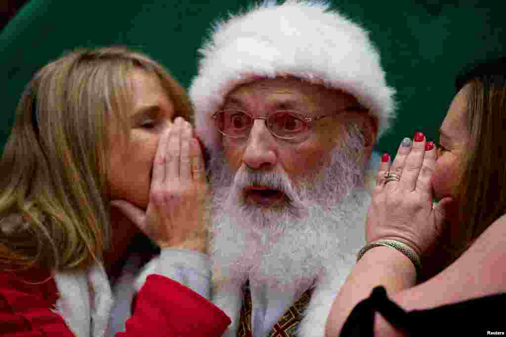 2018年12月8日,在美国宾夕法尼亚州的“普鲁士国王”购物中心,两位女子向圣诞老人倾诉心愿。这里是美国最大的零售中心。