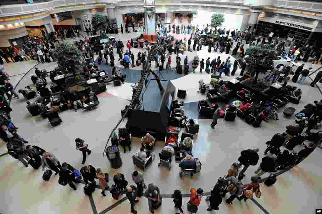 A long line of travelers winds around the atrium at Hartsfield-Jackson International Airport when operations return after the effects of a major winter storm halted flights for three days, Feb. 13, 2014, in Atlanta.