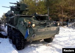 资料照片:在爱沙尼亚参加演习的美国军人准备从斯崔克装甲车上发射毒刺导弹。(2022年3月10日)