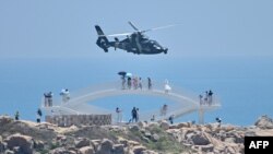 中国福建省平潭岛上的游客在观看中国军队在台湾附近举行的实弹军演。(2022年8月4日)