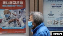 资料照:北京街头张贴鼓励老年人接种新冠疫苗的宣传画。(2022年3月30日)