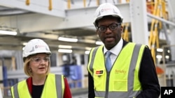 英国首相利兹·特拉斯(Liz Truss)10月14日将她的财政大臣夸西·克沃滕(Kwasi Kwarteng)革职。图为特拉斯和克沃滕2022年9月23日在一家工厂参观。-美联社资料照。