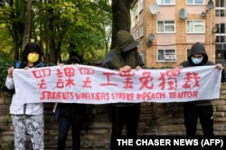 示威者在中国驻曼彻斯特领事馆外手持北京四通桥悬挂反习标语的横幅举行抗议。中国驻曼彻斯特领事馆工作人员随后出来把示威者扯进领事馆内进行殴打。（2022年10月16日）