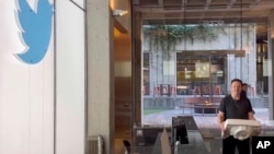 马斯克搬着一个洗手池盆进入在旧金山的推特总部。(2022年10月26日)