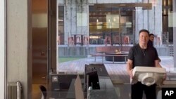 马斯克搬着一个洗手池盆进入在旧金山的推特总部。(2022年10月26日)