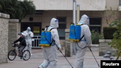 身穿防护服的防疫人员在北京一个被封的居民区喷洒消毒药水。(2022年11月9日)