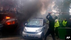 戴着面罩的示威者在巴黎抗议活动中砸汽车烧汽车。(2018年12月2日)