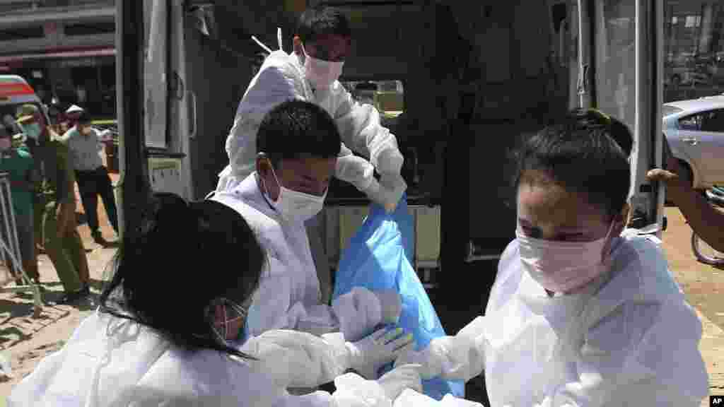 Giới chức Lào đưa thi thể của một nạn nhân tới một ngôi chùa ở thị trấn Pakse, Lào, ngày 18/10/2013.