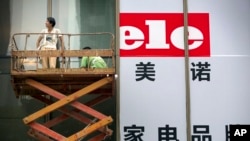 工人们为北京一家家用电器商店的大开张做准备。（2015年7月15日）