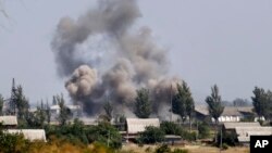 Khói bốc lên từ sau một vụ pháo kích vào thị trấn Novoazovsk, miền đông Ukraine, ngày 27/8/2014.