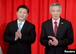 中国主席习近平和新加坡总理李显龙在两国谅解备忘录签字仪式上鼓掌(2015年11月7日)