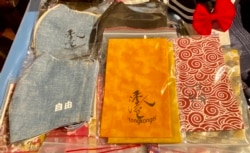 似水牛年迷你年宵市集售卖的布口罩、布利是封，印有象征抗争信念的标语 (美国之音汤惠芸)