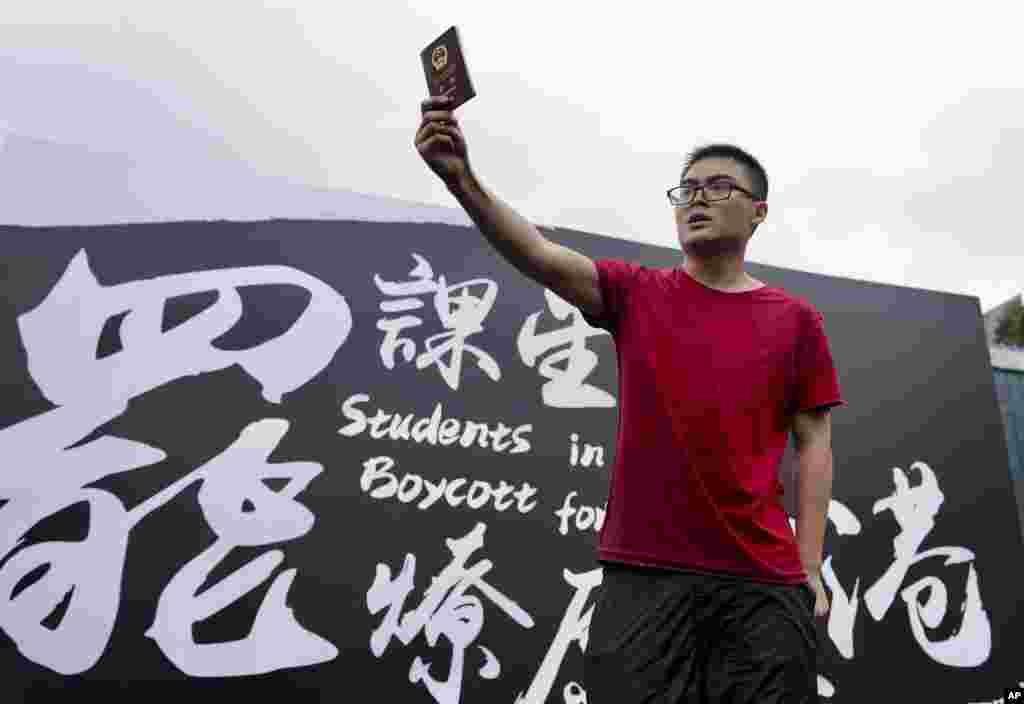 在抗议者在香港中文大学举行罢课集会之际,一位来自中国大陆的学生高举自己的中国护照向抗议者示威。(2019年9月2日)