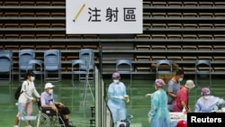 台湾医护人员在新北市的一个体育馆为85岁以上的老人接种新冠疫苗。(2021年6月15日)