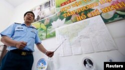 Đại tá Đỗ Đức Minh, Phó tham mưu trưởng Quân chủng Phòng không-Không quân Việt Nam cạnh bản đồ khu vực tìm kiếm chuyến bay MH370 bị mất tích trong một cuộc họp báo tại TPHCM, ngày 13/3/2014.